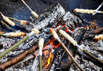 Am Lagerfeuer wird Stockbrot gebacken.