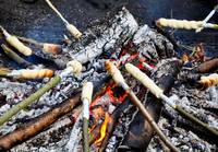 Am Lagerfeuer wird Stockbrot gebacken.