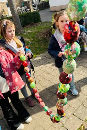 Die Vorschulkinder schmücken den Osterbrunnen.